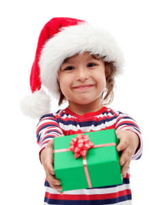 Adorable little boy offering a christmas present